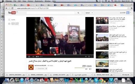 Mourners hold Basil's portrait and wave the flag of Syria