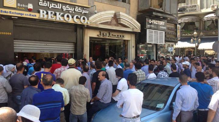 Syrians crowd around an exchange location